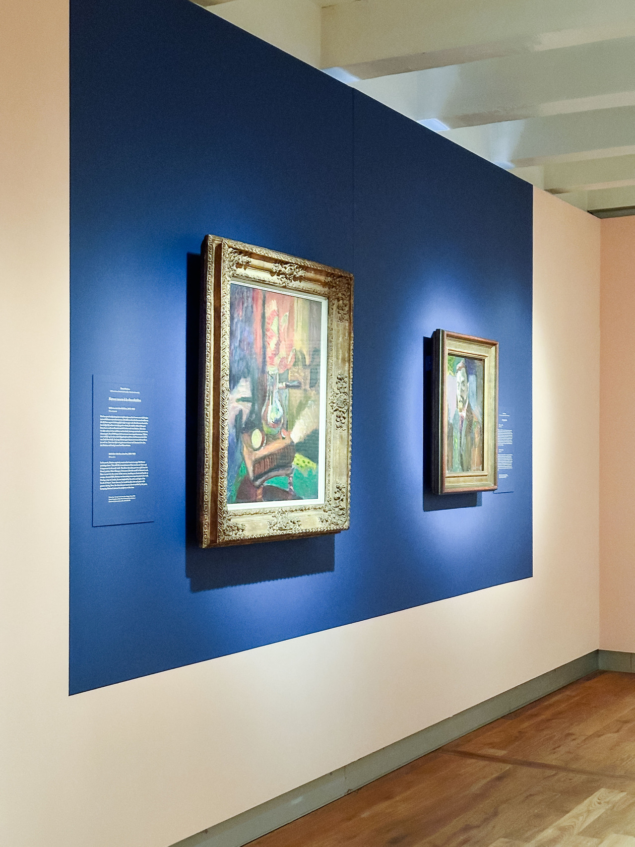 Gallery room at the Chez Matisse exhibition with paintings displayed on blue walls.