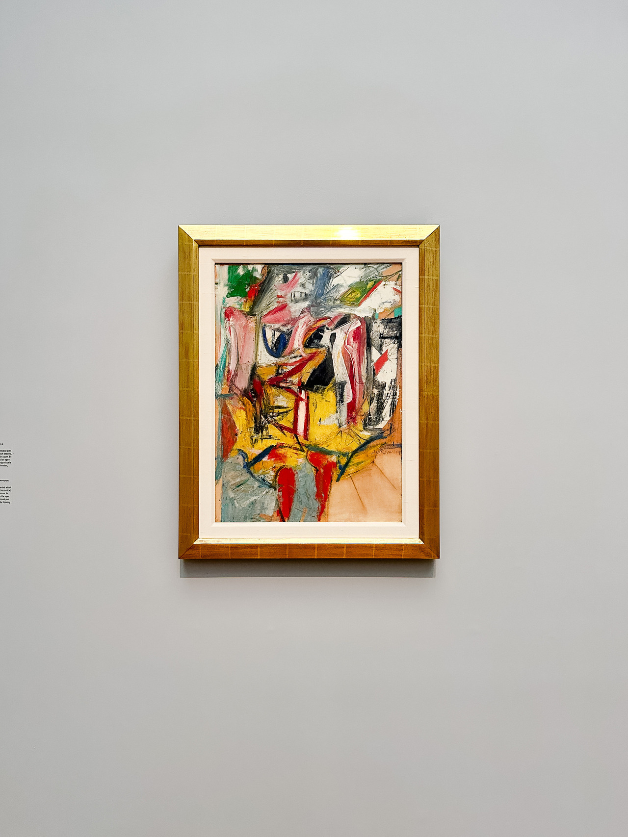 Colourful Willem de Kooning painting in a gold frame on a white gallery wall at the Rijksmuseum.