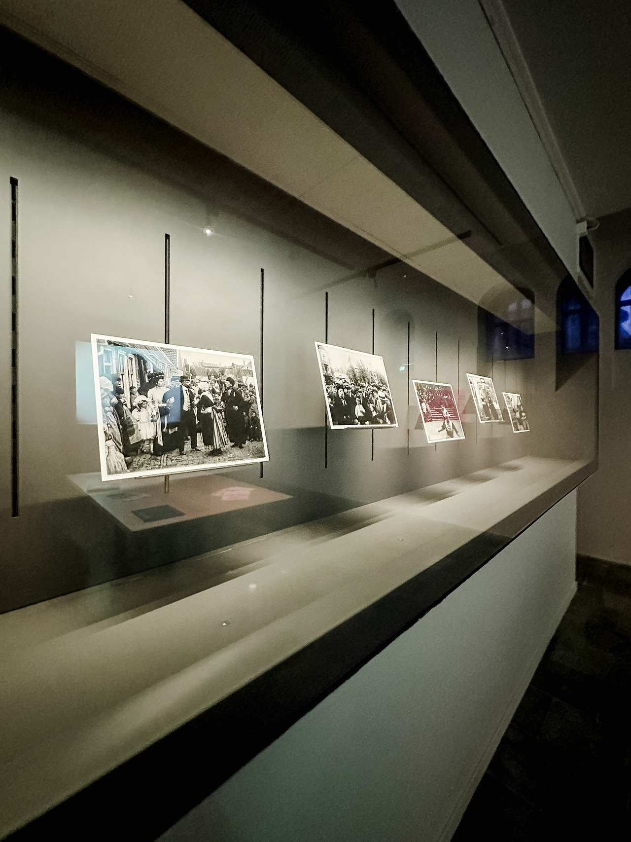 Historical black-and-white photographs documenting the career of revue performer Louisette, displayed in a long glass museum case.