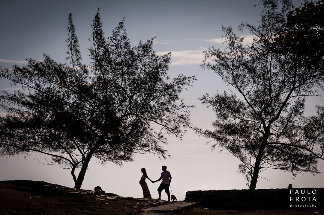 casal de silhueta de perfil com cachorrinho. duas arvores emolduram o casal