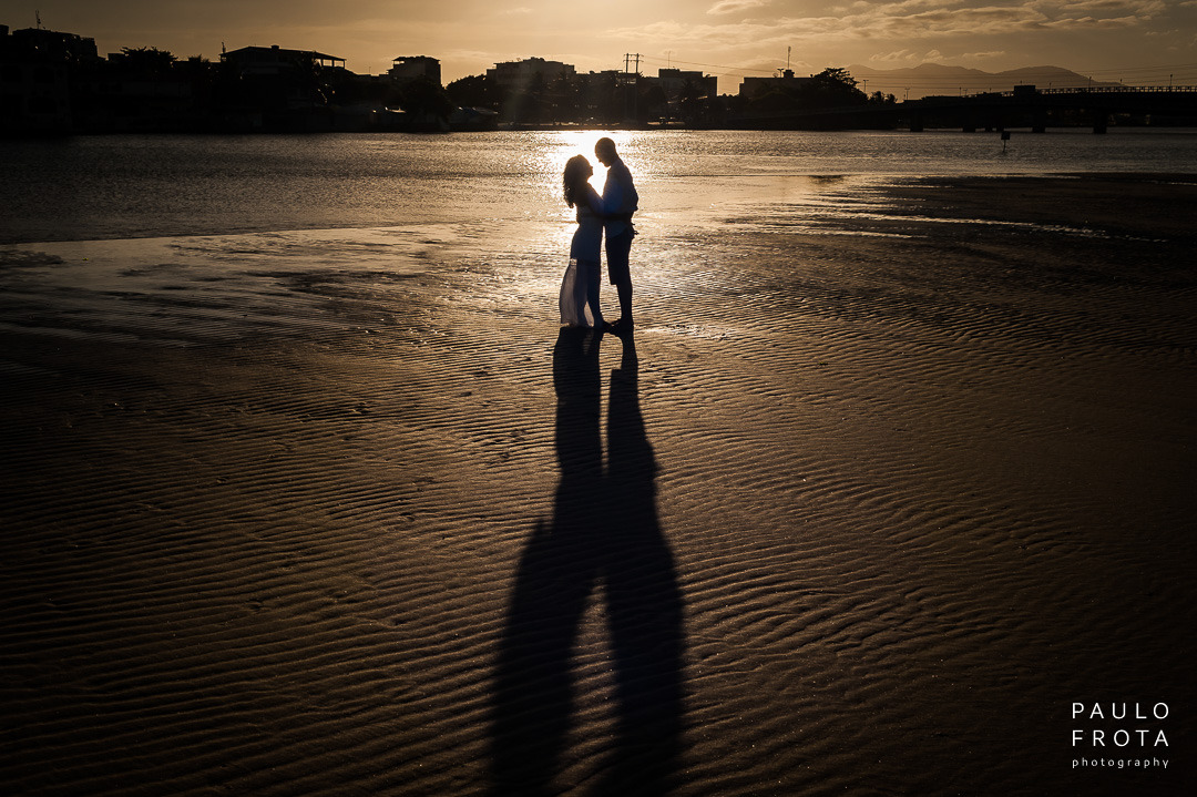 casal ao sol na lagoa de saquarema. Casal em silhueta e o sol refletindo na agua.