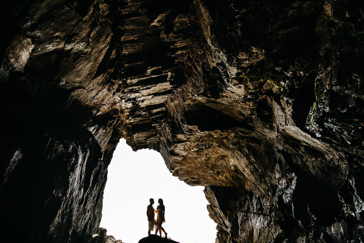 silhueta de casal de dentro para fora em caverna