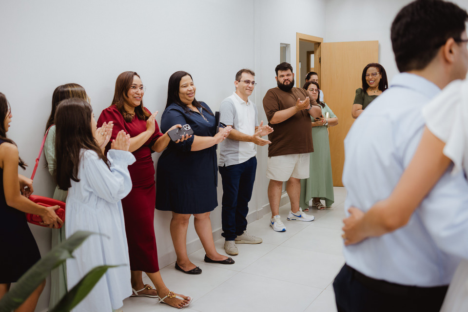 Convidados aplaudindo no corredor do cartório durante a celebração do casamento civil