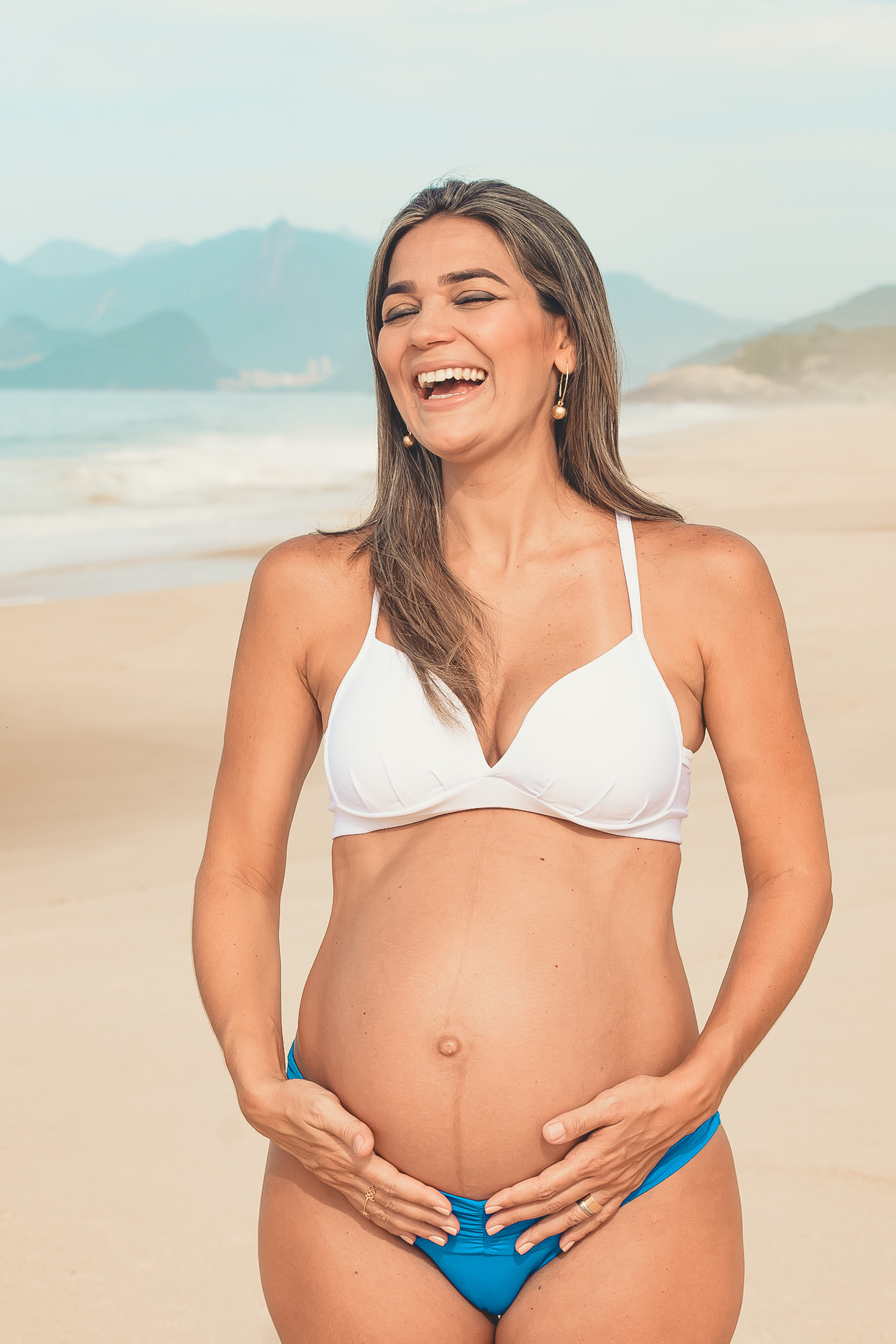 ensaio de gestante em praia de niterói e la toca a barriga e sorri
