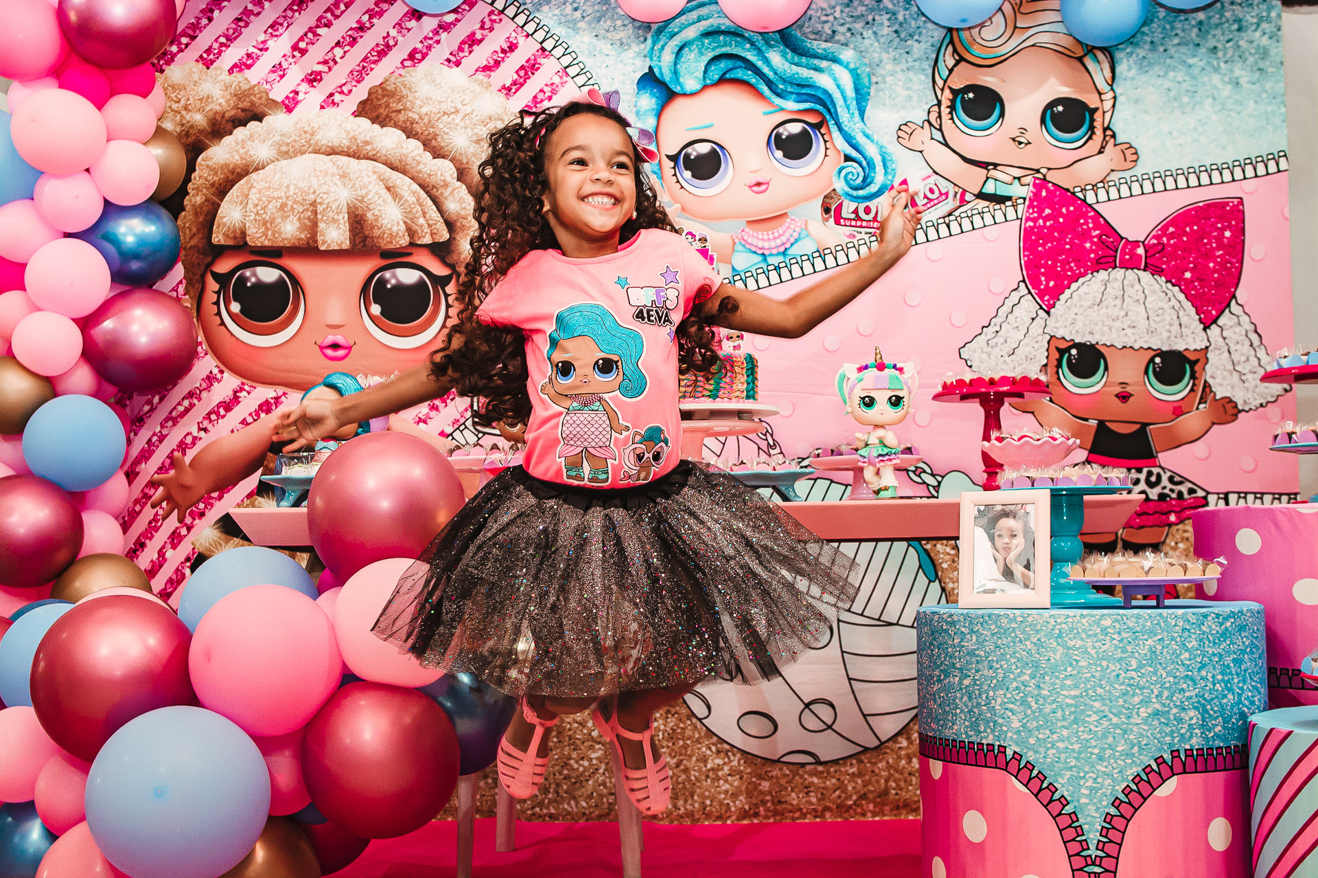 aniversariante pula a frente da mesa decorada do bolo com sorriso