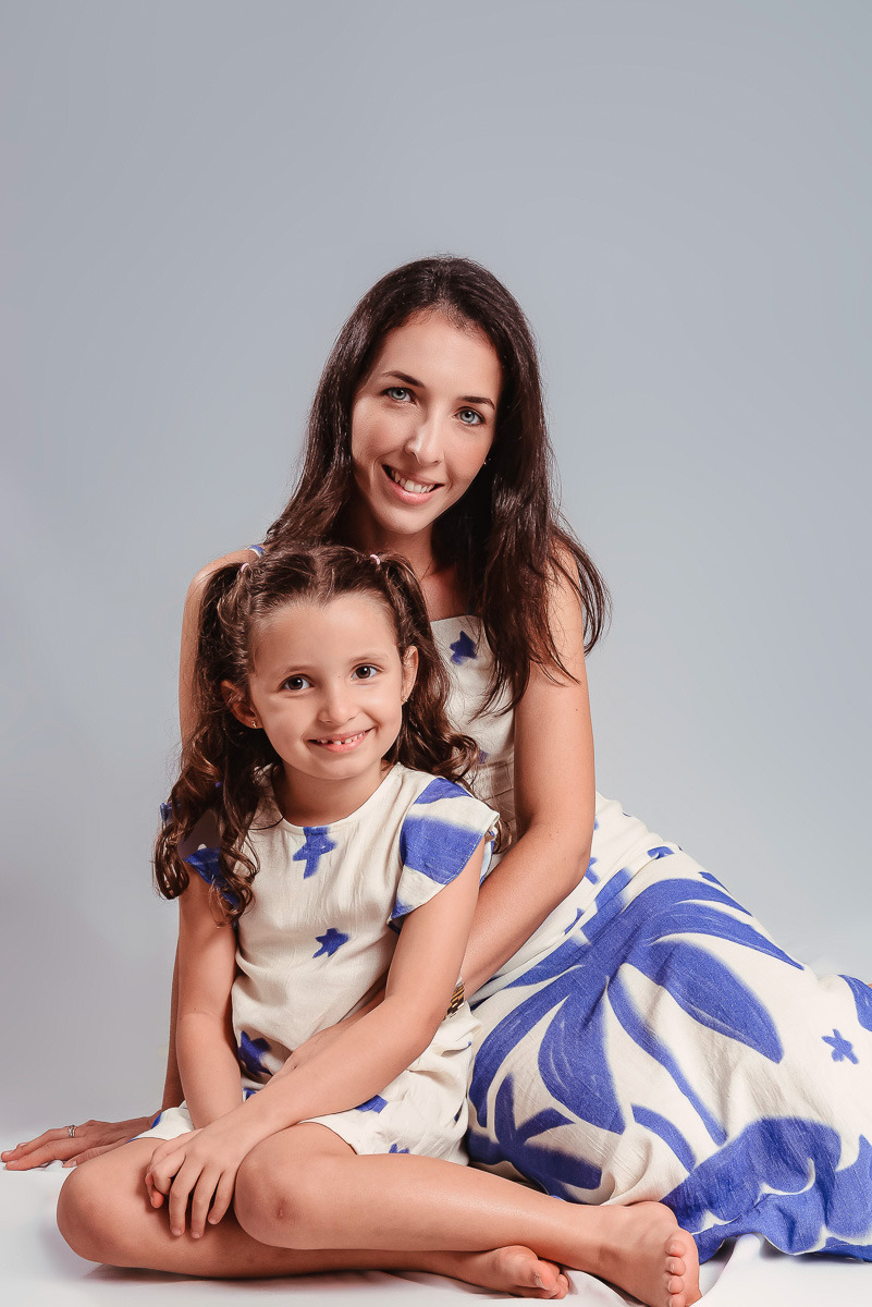 ensaio de família e mãe e filha em estúdio no centro de niterói. A mãe e filha estão vestindo vestidos estampados azul no estilo tal mãe tal filha