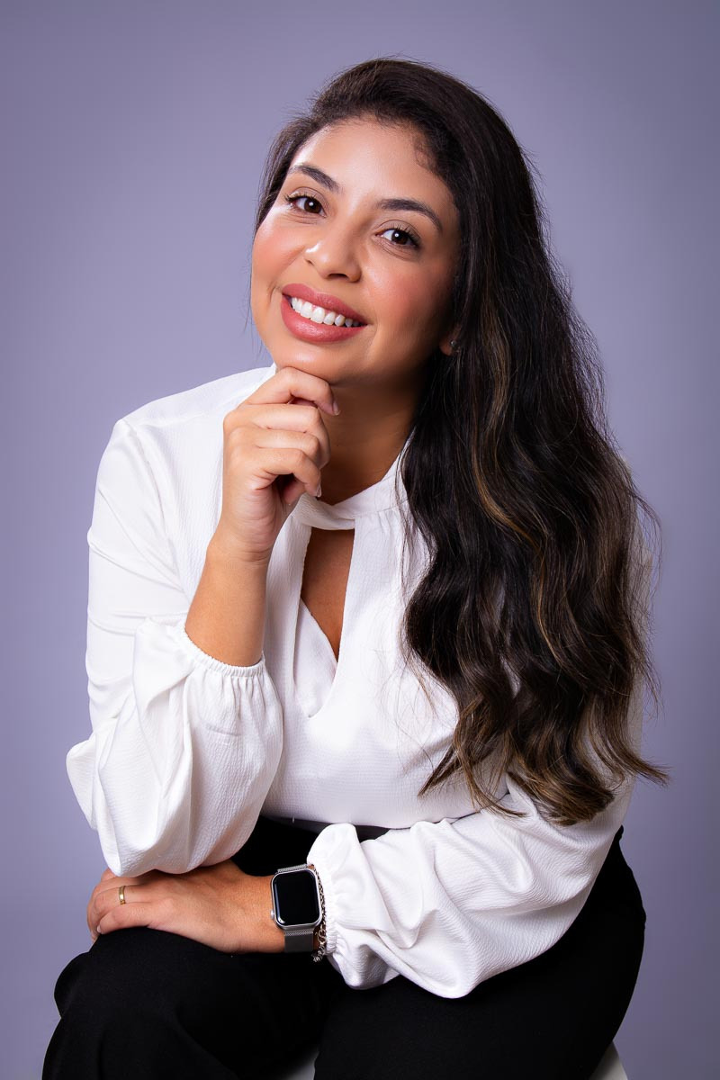 bancária posando para retratos corporativos sentada olhando para a camera sorrindo