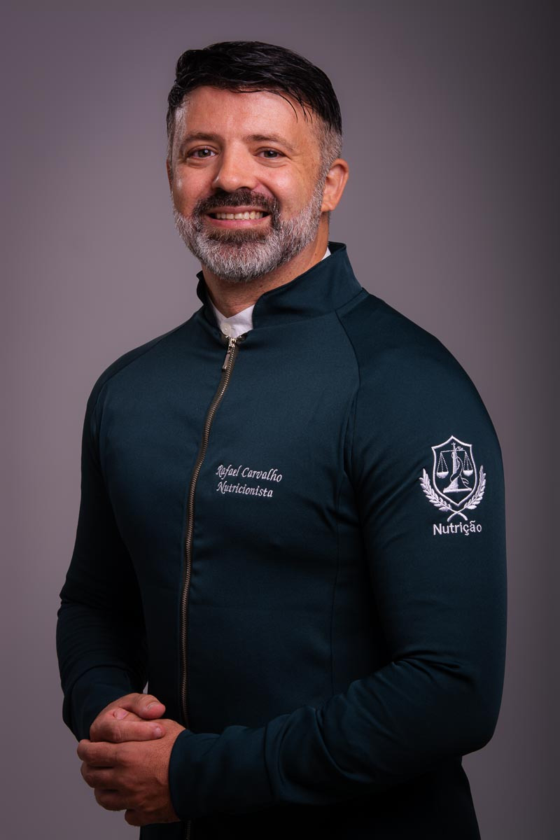 profissional de saúde nutricionista posando para retratos corporativos com fundo cinza e uniforme verde