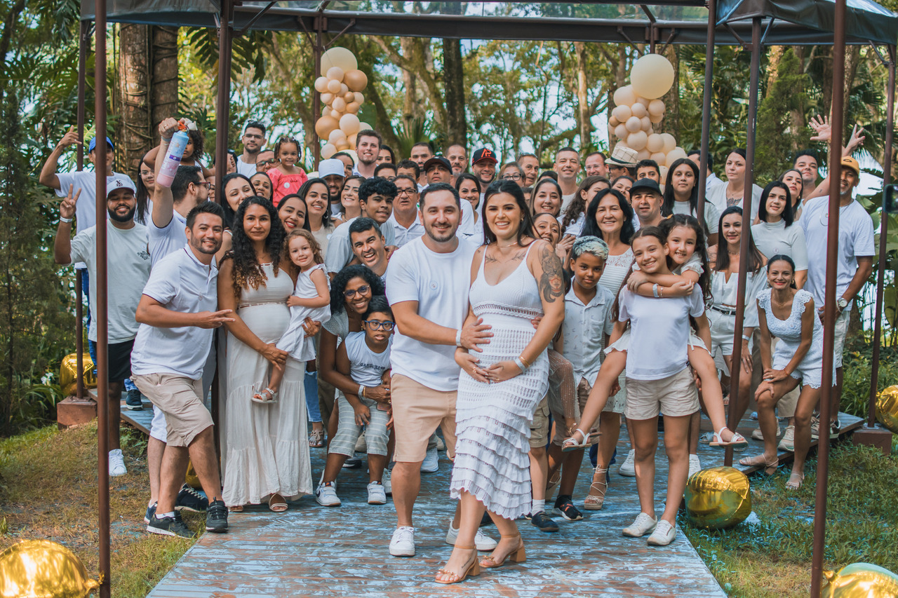 A imagem contém varias pessoas vestidas de branco.
