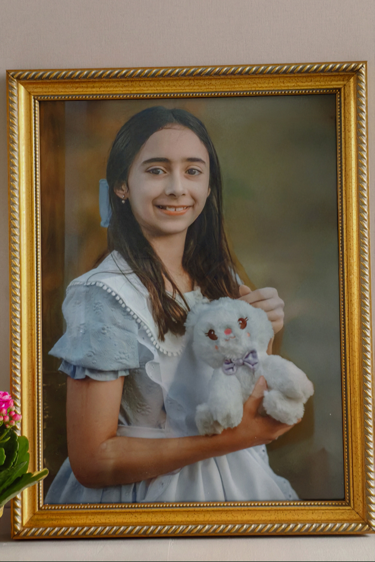 Quadro grande com a foto de uma menina sorrindo e segurando um coelho branco de pelúcia.