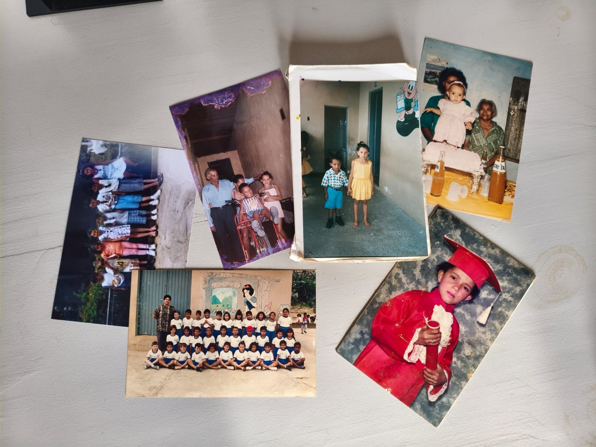 Conjunto de fotografias antigas espalhadas sobre uma mesa clara, mostrando momentos de infância, família, festa e formatura escolar.