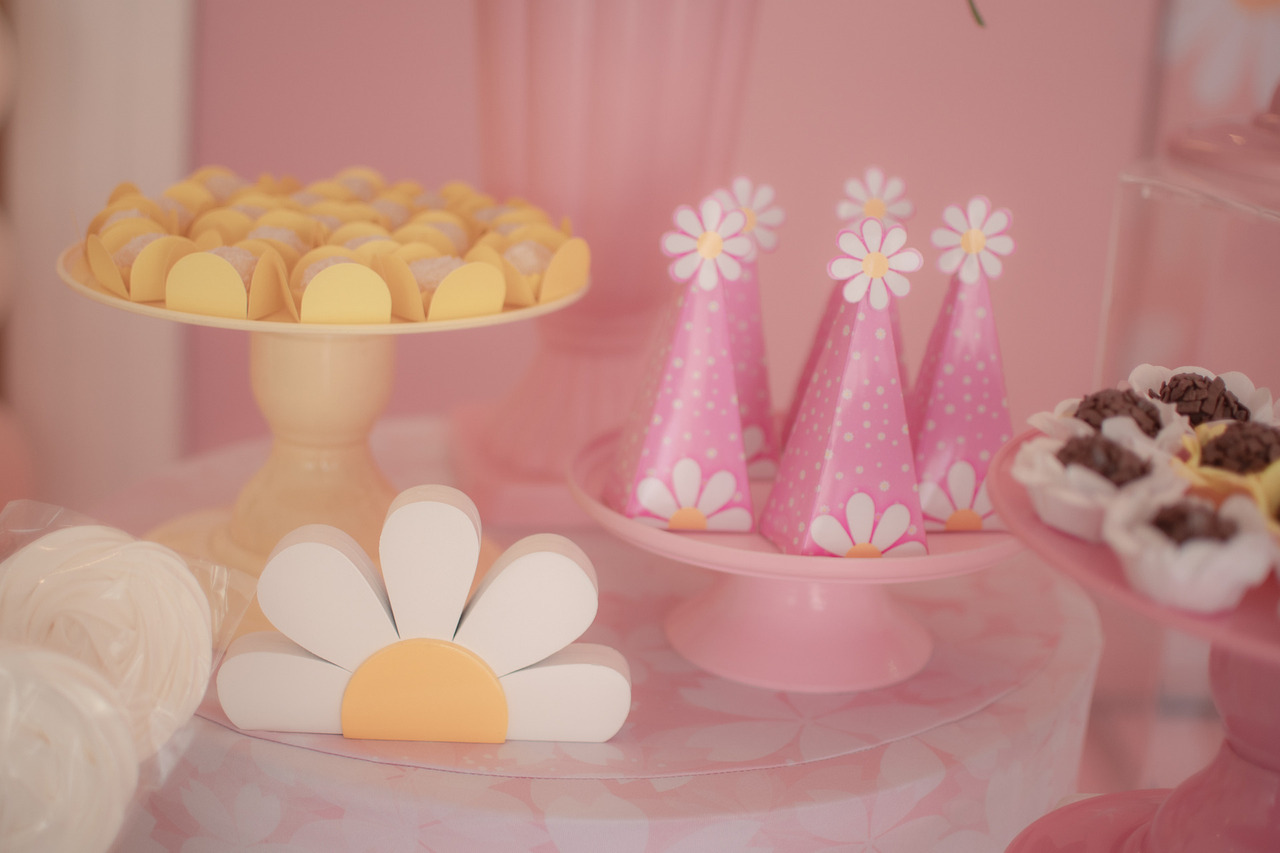 Decoração de aniversário infantil, com doces e enfeites de margaridas.