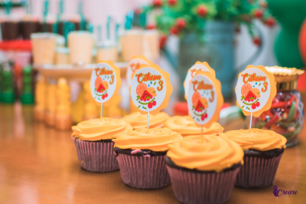 Coopcake de aniversário infantil com cobertura amarela e uma plaquinha sinalizando os 3 anos da criança e o tema frutas.