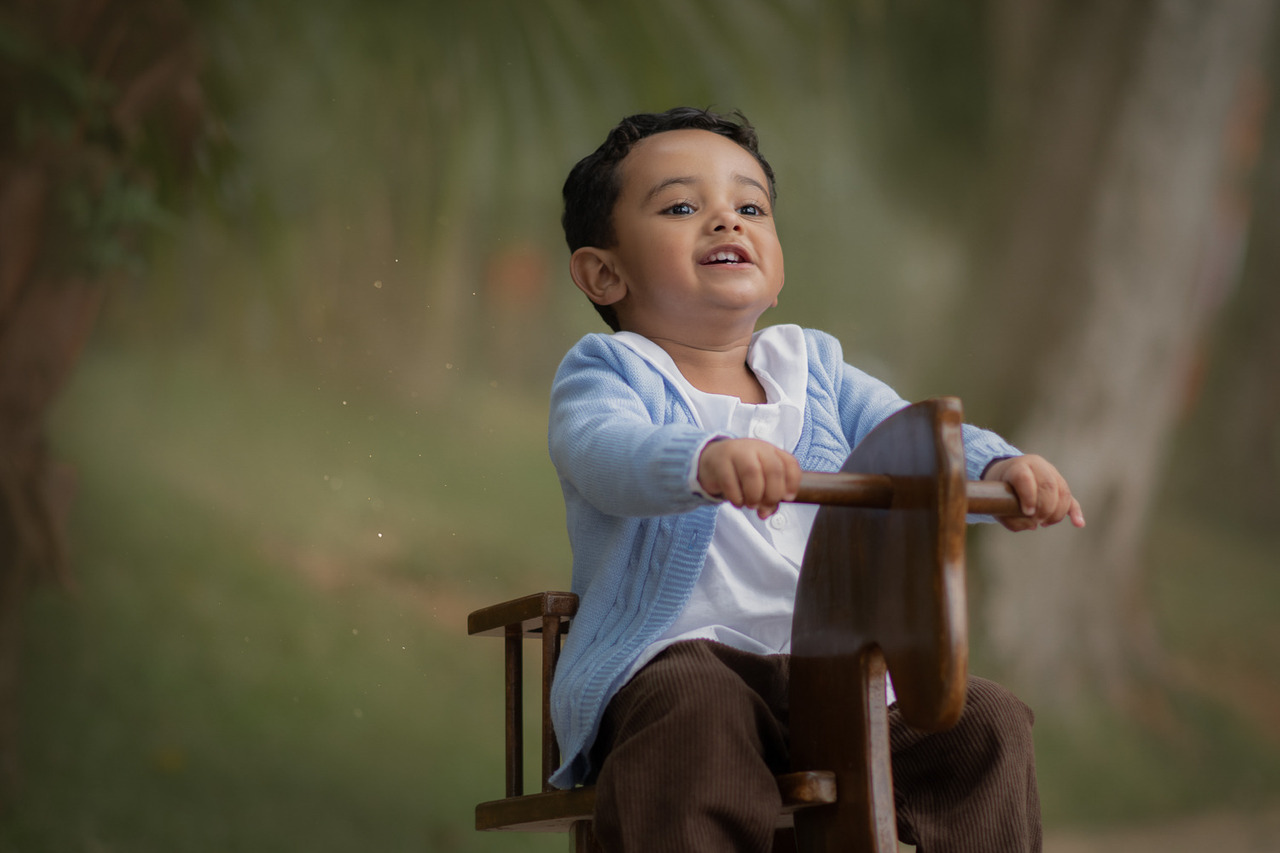 um menino de 2 anos, brincando em um cavalinho de madeira, durante su ensaio fotográfico no Parque Luís Carlos Grecco em Ribeirão Pires.