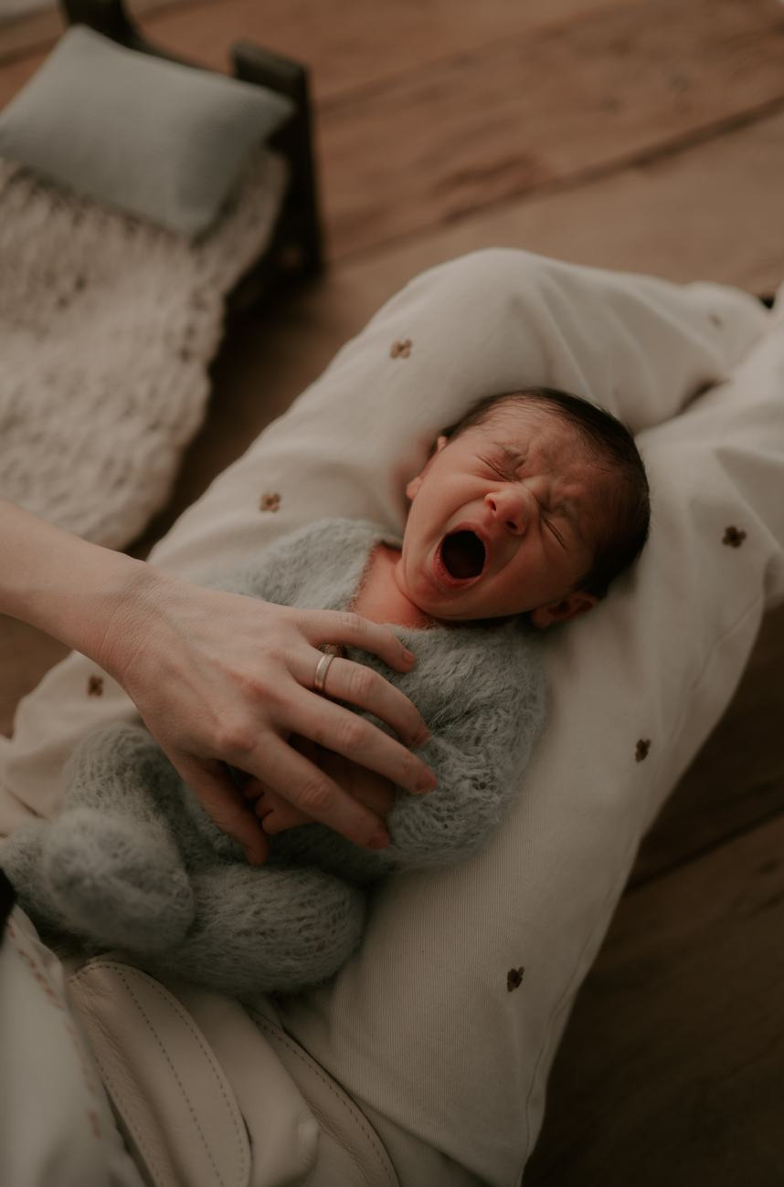 Um bebê boceja, acomodado, durante o ensaio
