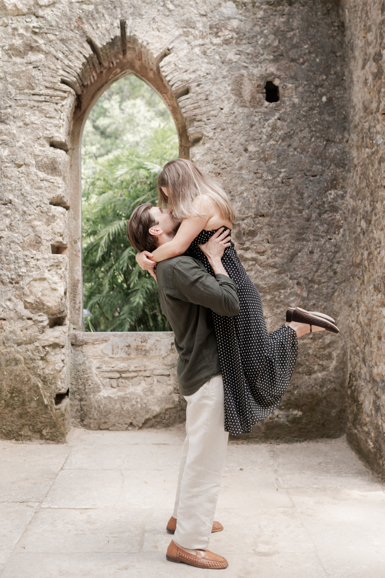 Catherine and Zach at the balustrade beneath the carved arches of Palácio de Monserrate, Sintra, engagement photography by Mariana Castanheira