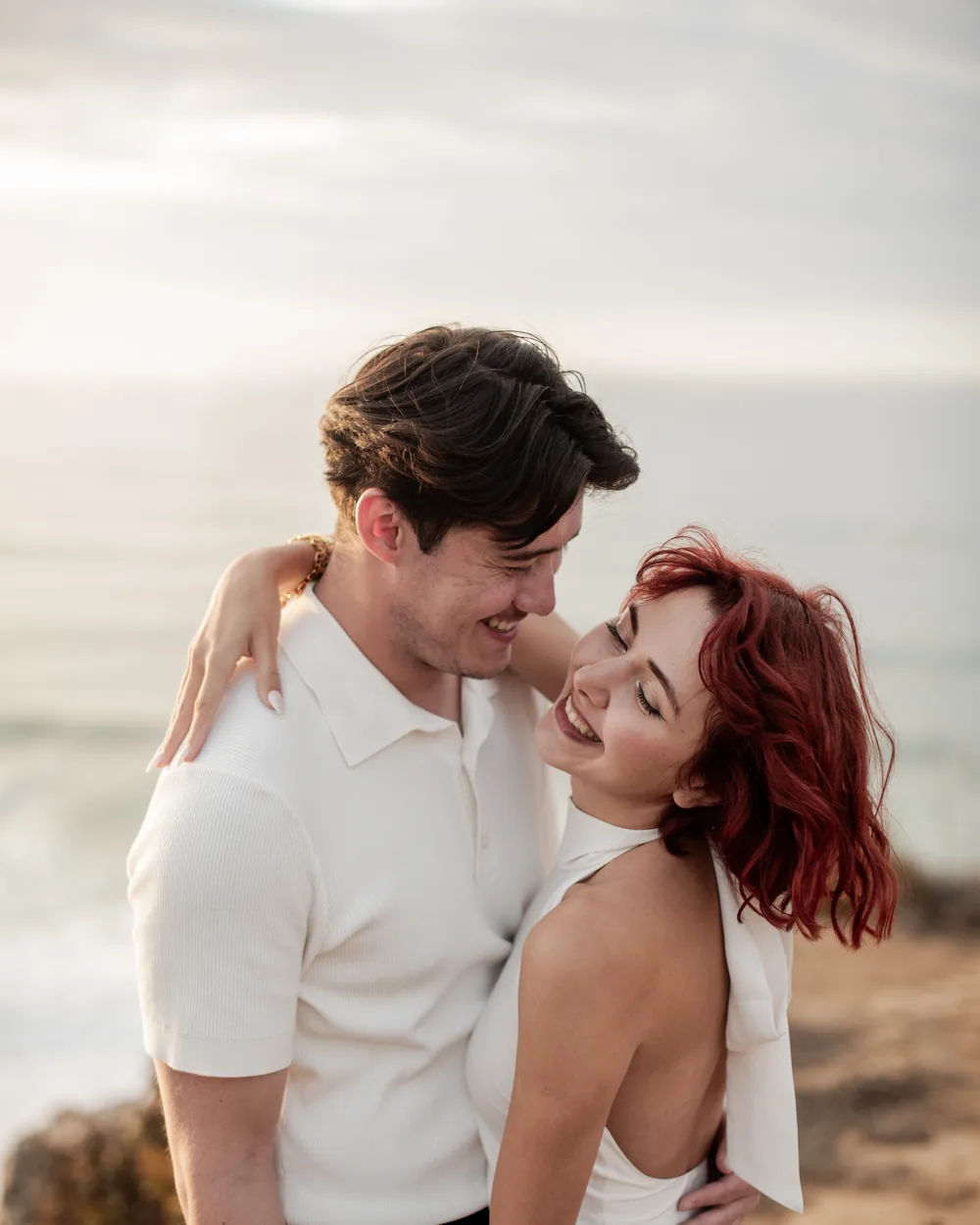 Newly engaged couple laughing at sunset above the Atlantic in Azenhas do Mar, Sintra proposal photography by Mariana Castanheira