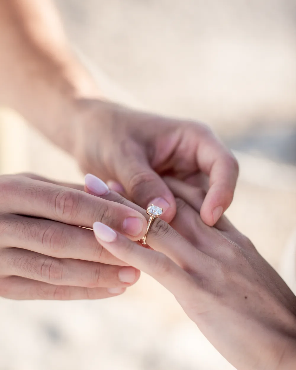 Engagement ring being placed on her finger after the proposal at Guincho, Cascais proposal photography by Mariana Castanheira