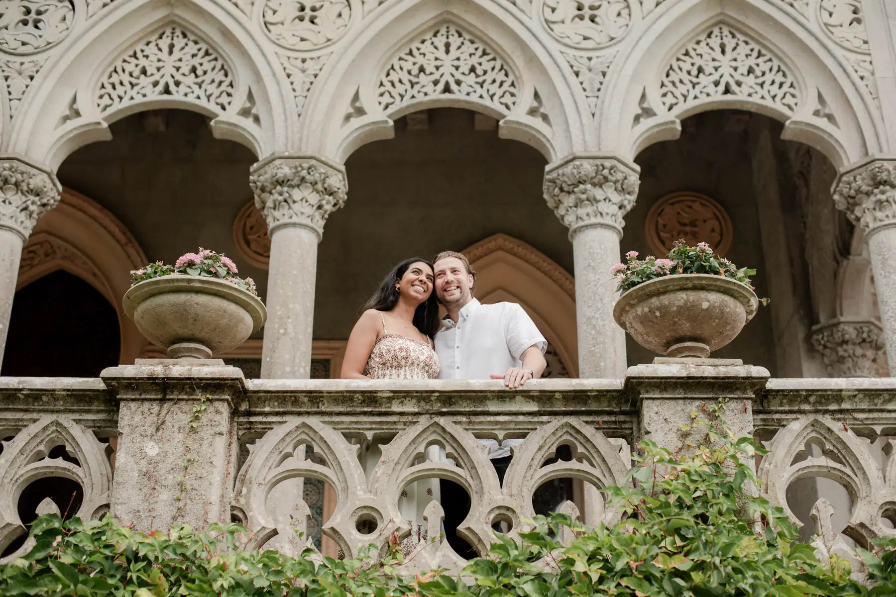 Newly engaged couple on the carved arcaded balcony of Palácio de Monserrate, Sintra proposal photography by Mariana Castanheira