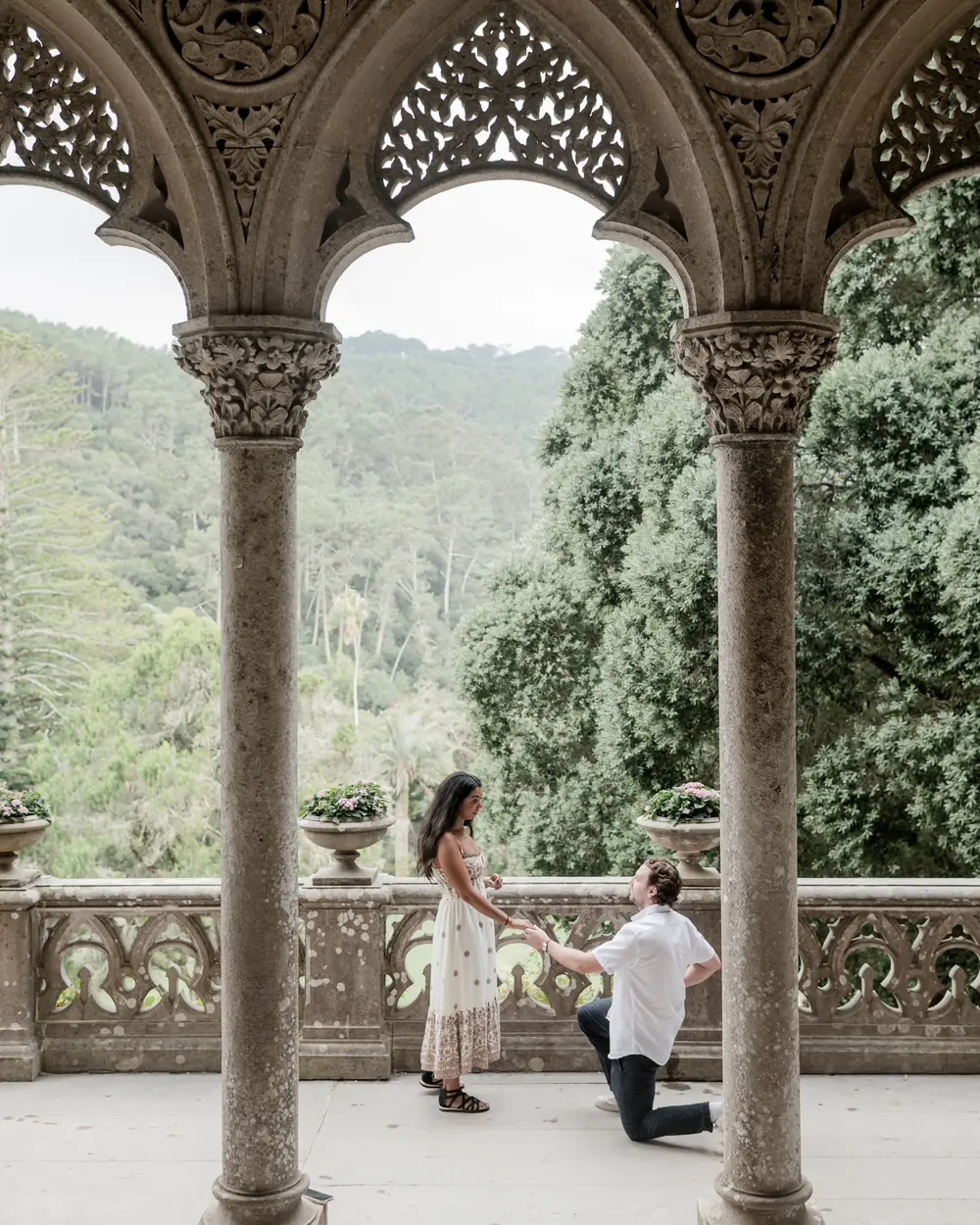 Surprise proposal on one knee framed by the arches of the terrace at Monserrate, Sintra proposal photography by Mariana Castanheira