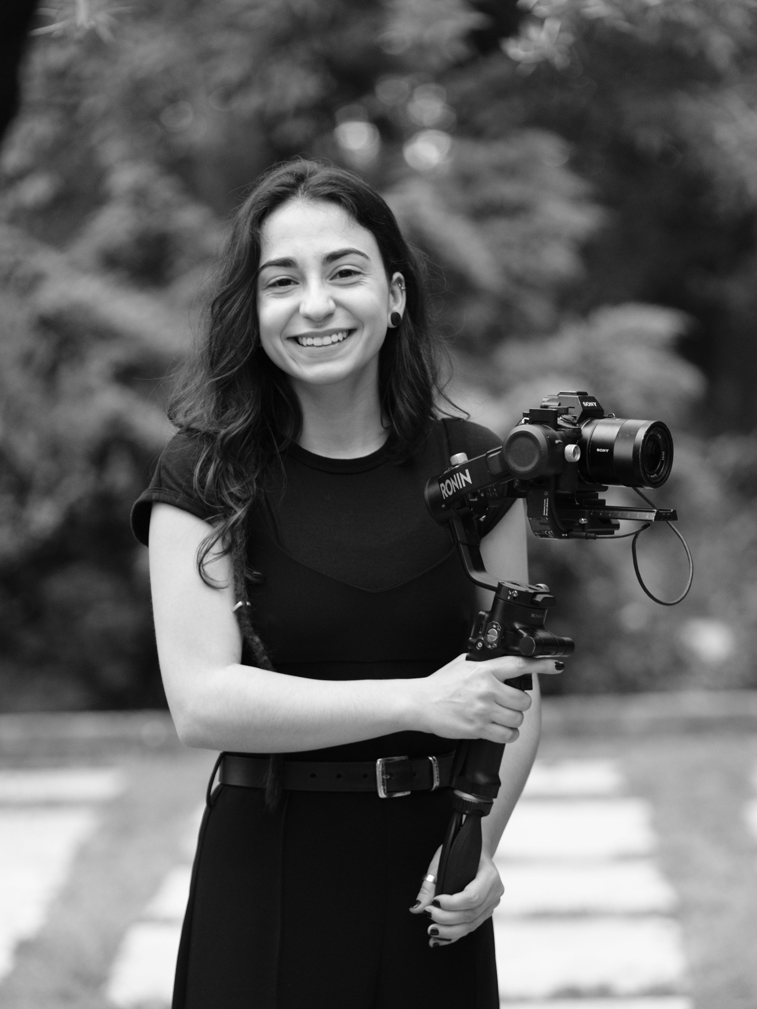 videografa da equipa Filipe Santos com a camara na mão e a sorrir no jardim da quinta