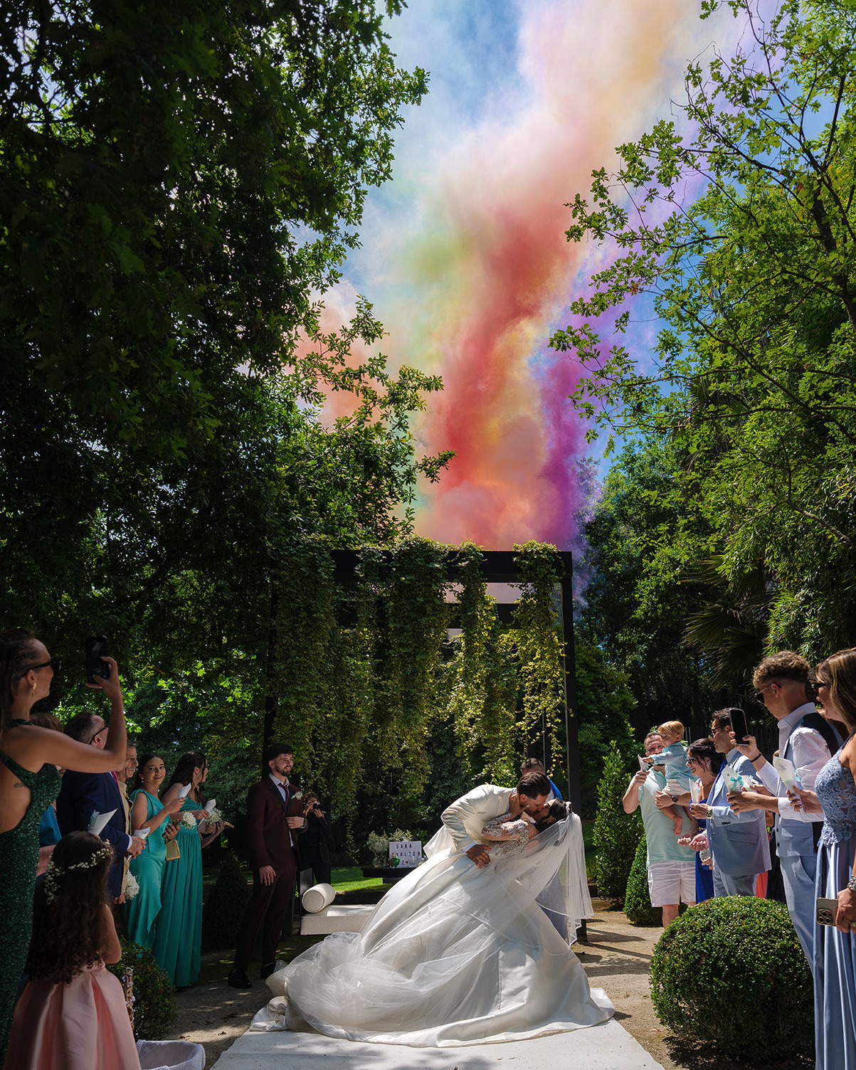 noiva a sorrie enquanto sai de casa com o ramo de flores numa mão e uma garrafa de tequila na outra