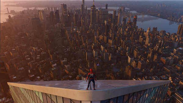 Homem-aranha do alto de um prédio tringular, centralizado na foto e de costas para a câmera contemplando o o pôr-do-sol com os prédios ao fundo.