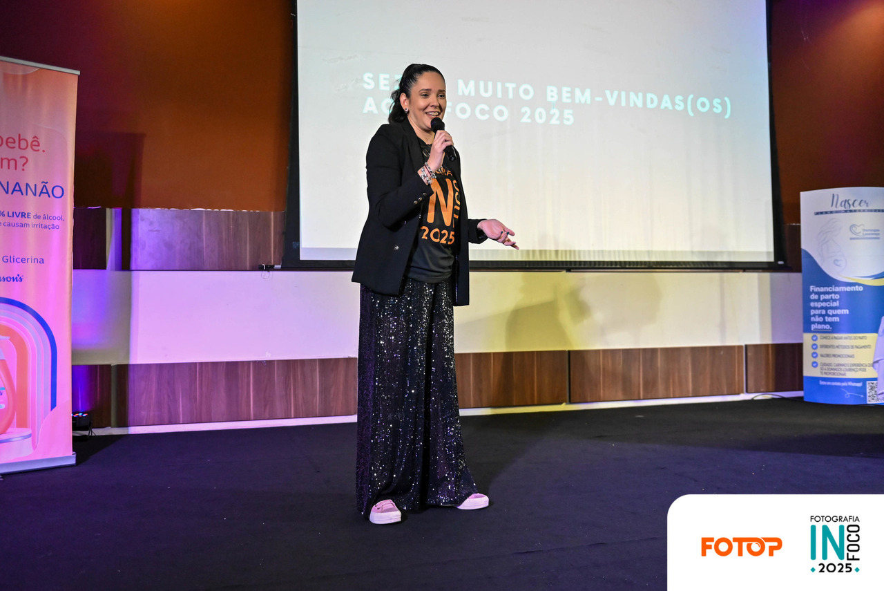 Fernanda Caetano abre oficialmente o congresso de fotografia InFoco 2025 em Nova Iguaçu, dando boas-vindas aos fotógrafos participantes no palco do evento.