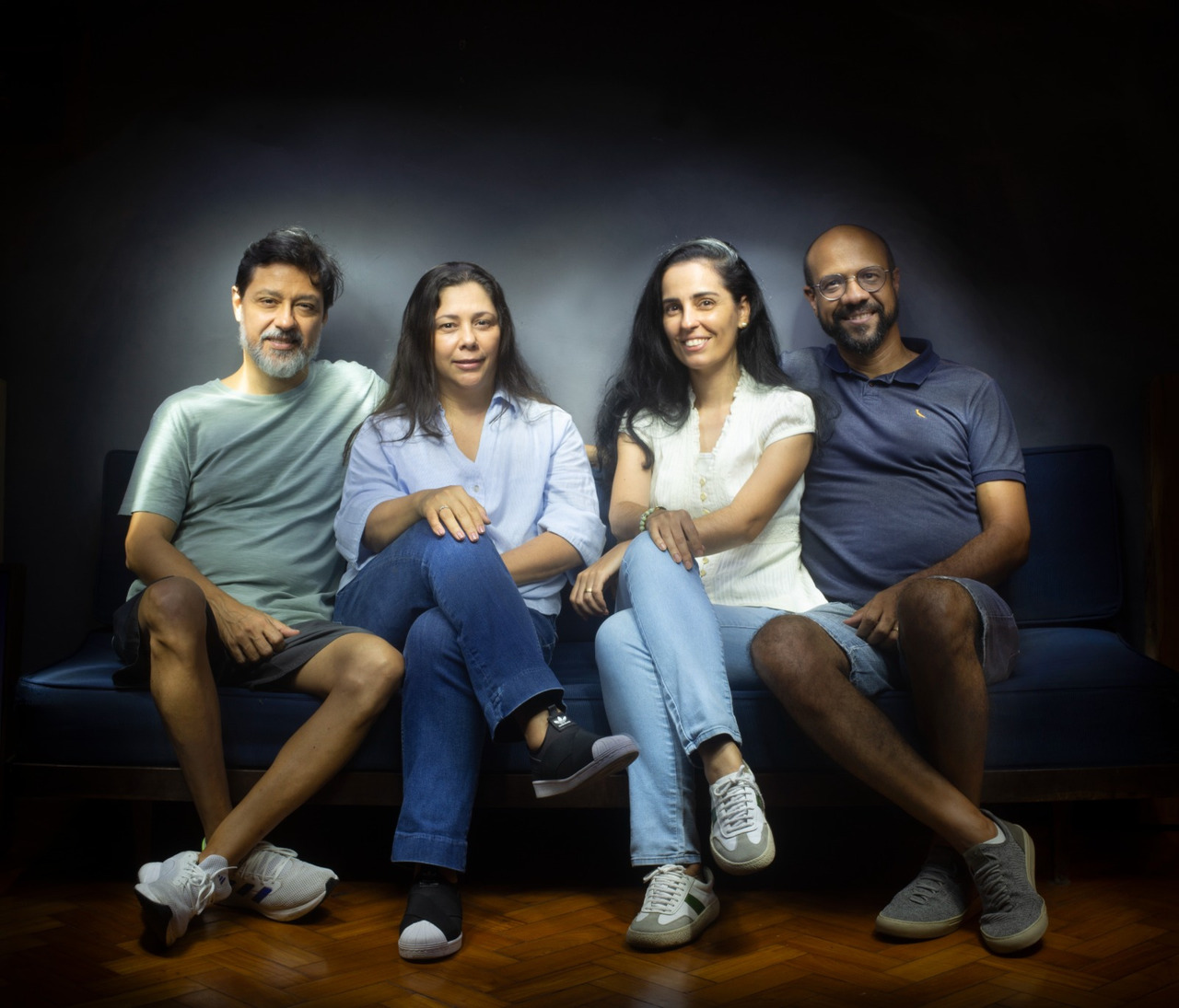 Foto de dois casais em um sofá azul fotografados pela técnica do lightpainting por Renan Cepeda