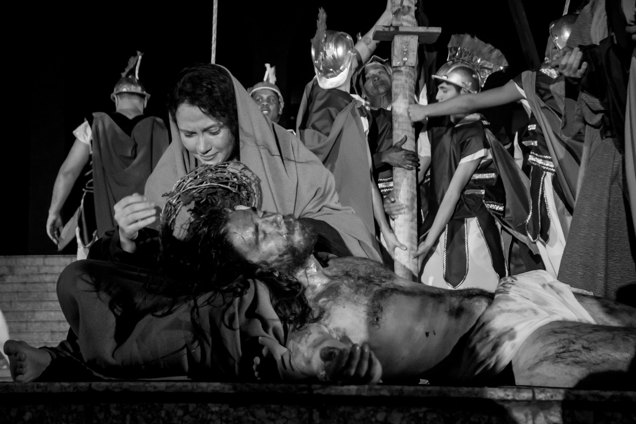 Maria segura o corpo de Jesus em um registro em preto e branco que transmite a profundidade da dor e a beleza da compaixão. Uma imagem atemporal de fé e humanidade.