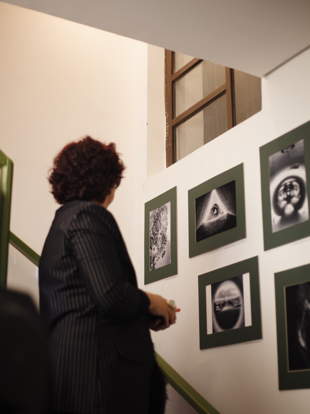 Visitante observa obras da mostra expostas na escada da Galeria Walter Firmo, em Florianópolis.