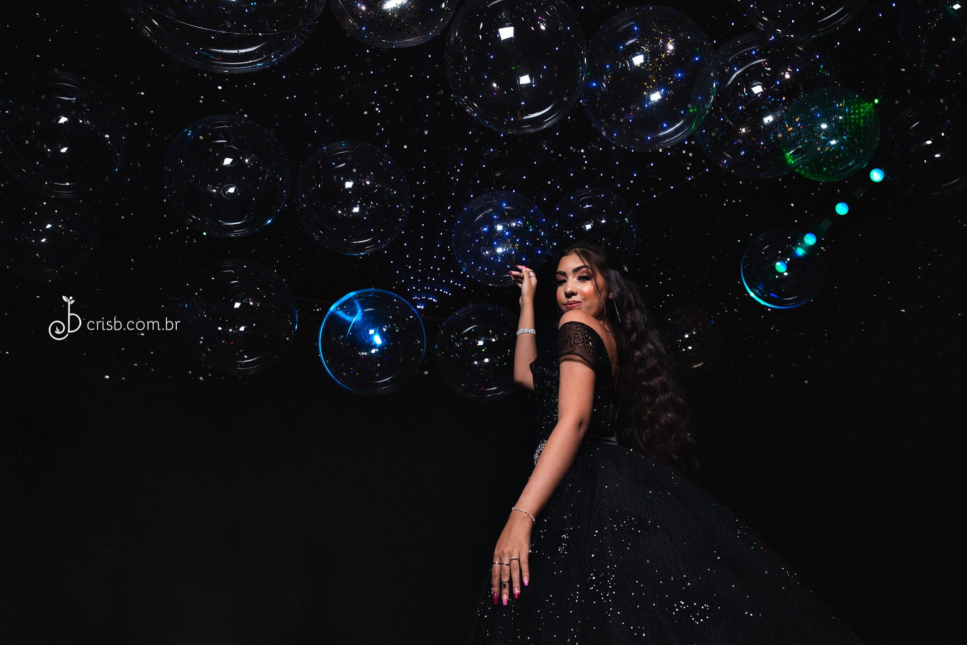 Foto de família sorrindo e muito animada atrás da mesa do bolo de 15 anos da aniversariante com tema azul