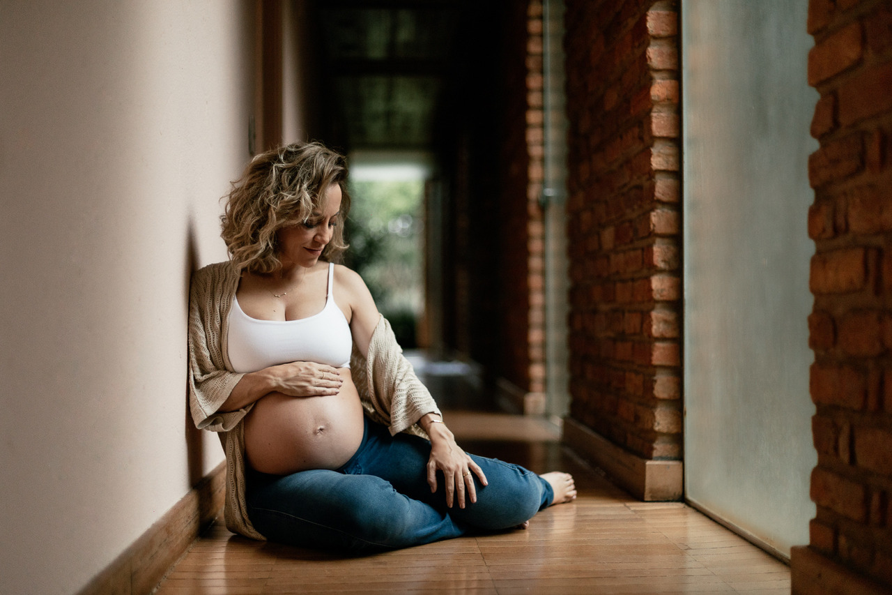 gestante sentada com calca jeans