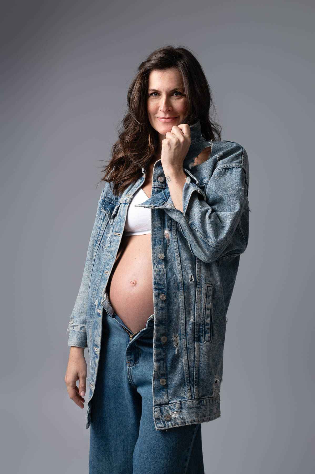 gestante em estudio sob uma luz suave e foto atemporal