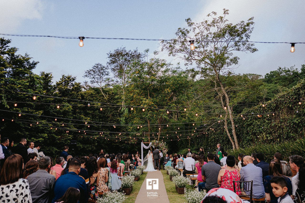 Casamento ao ar livre, espaço de cerimonia rodeado por natureza com a noiva e noivo ao centro
