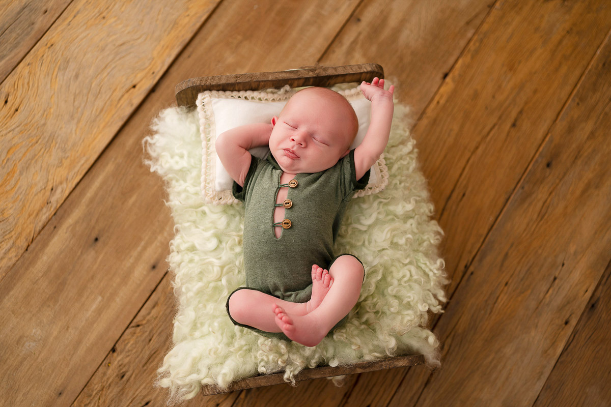 Bebê deitado em cama com pêlos