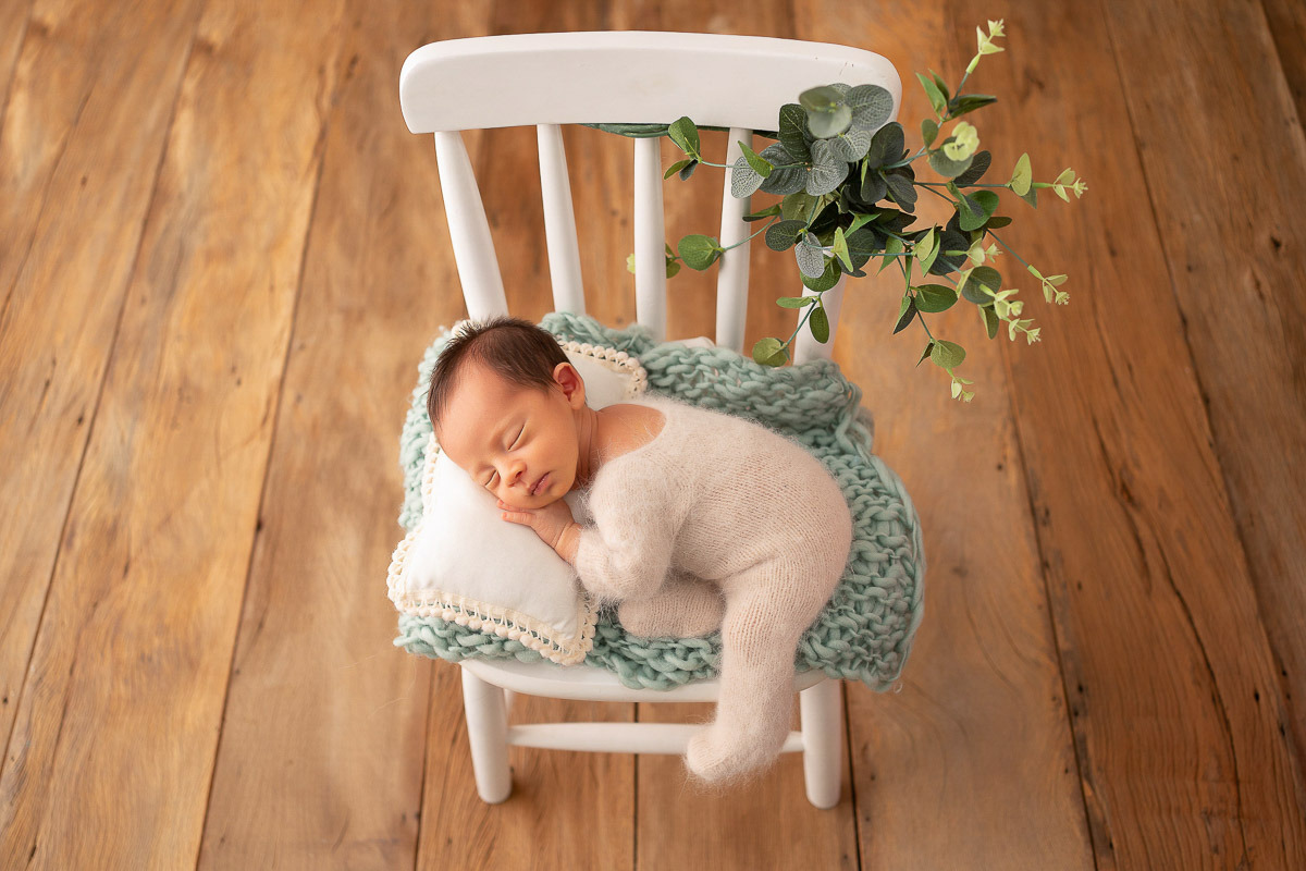 Bebê em cadeira de balanço branca
