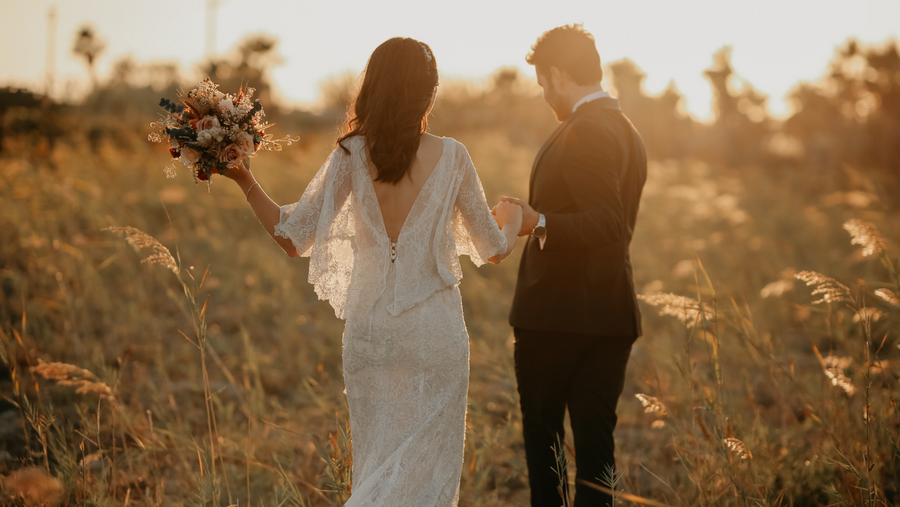 [IMAGEM: Casal caminhando de mãos dadas após a cerimônia, sorrindo, ALT TEXT: Casal feliz e relaxado após o casamento, fotografia de casamento autêntica]