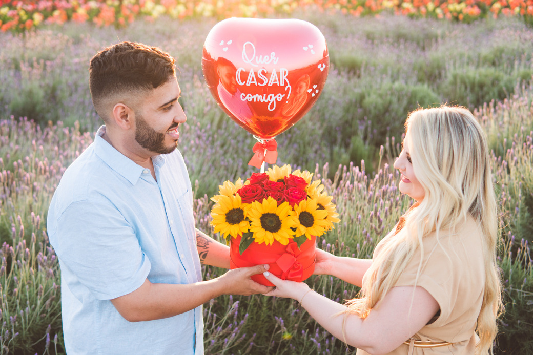 Fotografia de um pedido de casamento surpresa  no por do sol e em um campo de lavanda no parque Macena Flores em Holambra