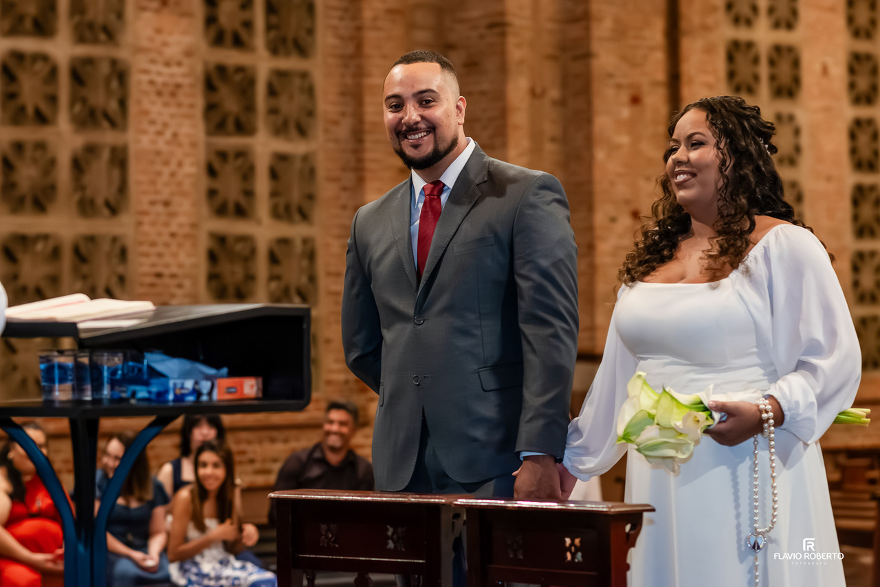 Noivos no altar sorrindo durante cerimônia religiosa no Santuário Nacional de Aparecida SP