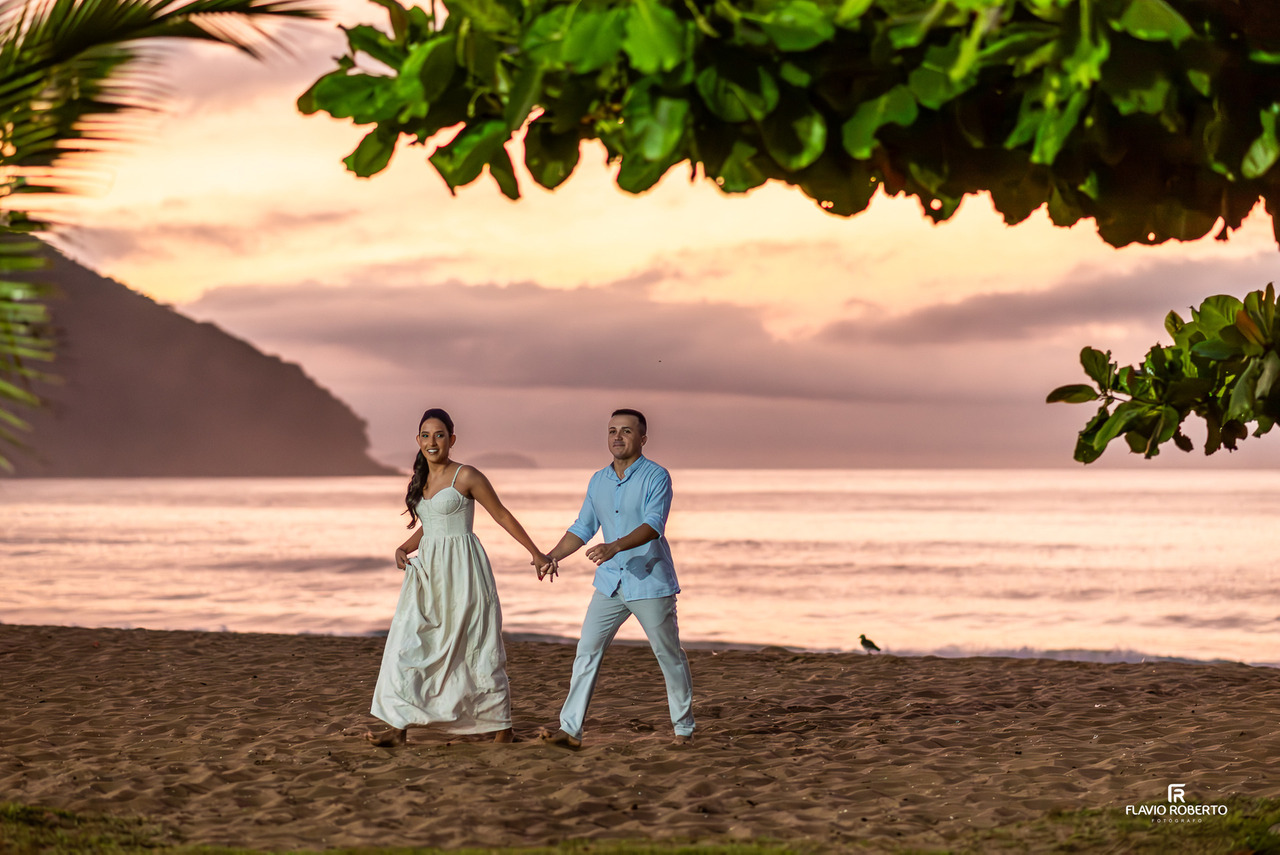 ensaio pré wedding em Ubatuba casal caminhando na praia ao nascer do sol com luz suave