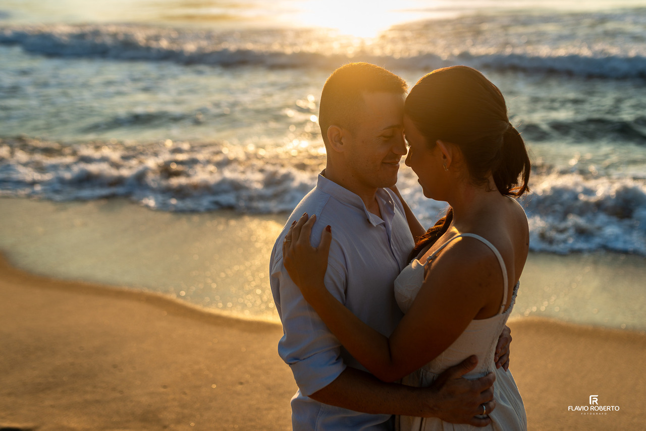 ensaio de casal na praia em Ubatuba com clima romântico e luz dourada do pôr do sol