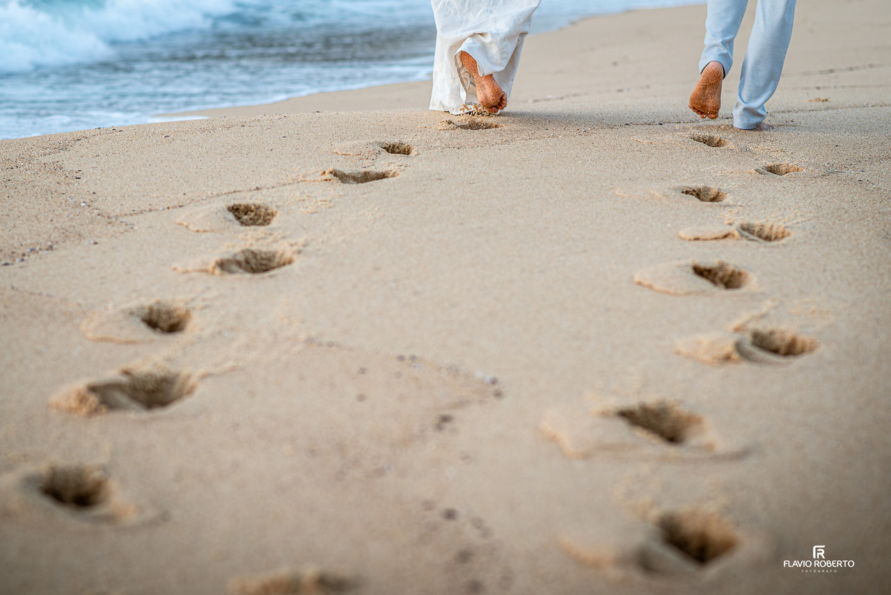 detalhe de pés na areia durante ensaio pré wedding em Ubatuba com pegadas na praia