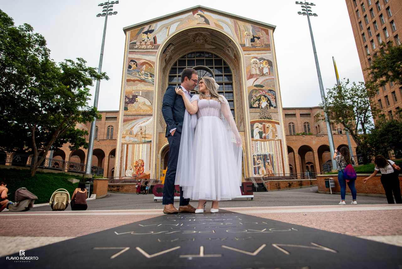 Casal fotografado entre os arcos do Santuário Nacional de Aparecida