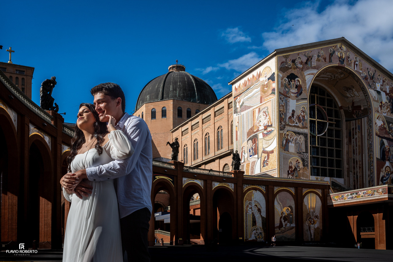 Casal fotografado entre elementos arquitetônicos do Santuário Nacional de Aparecida