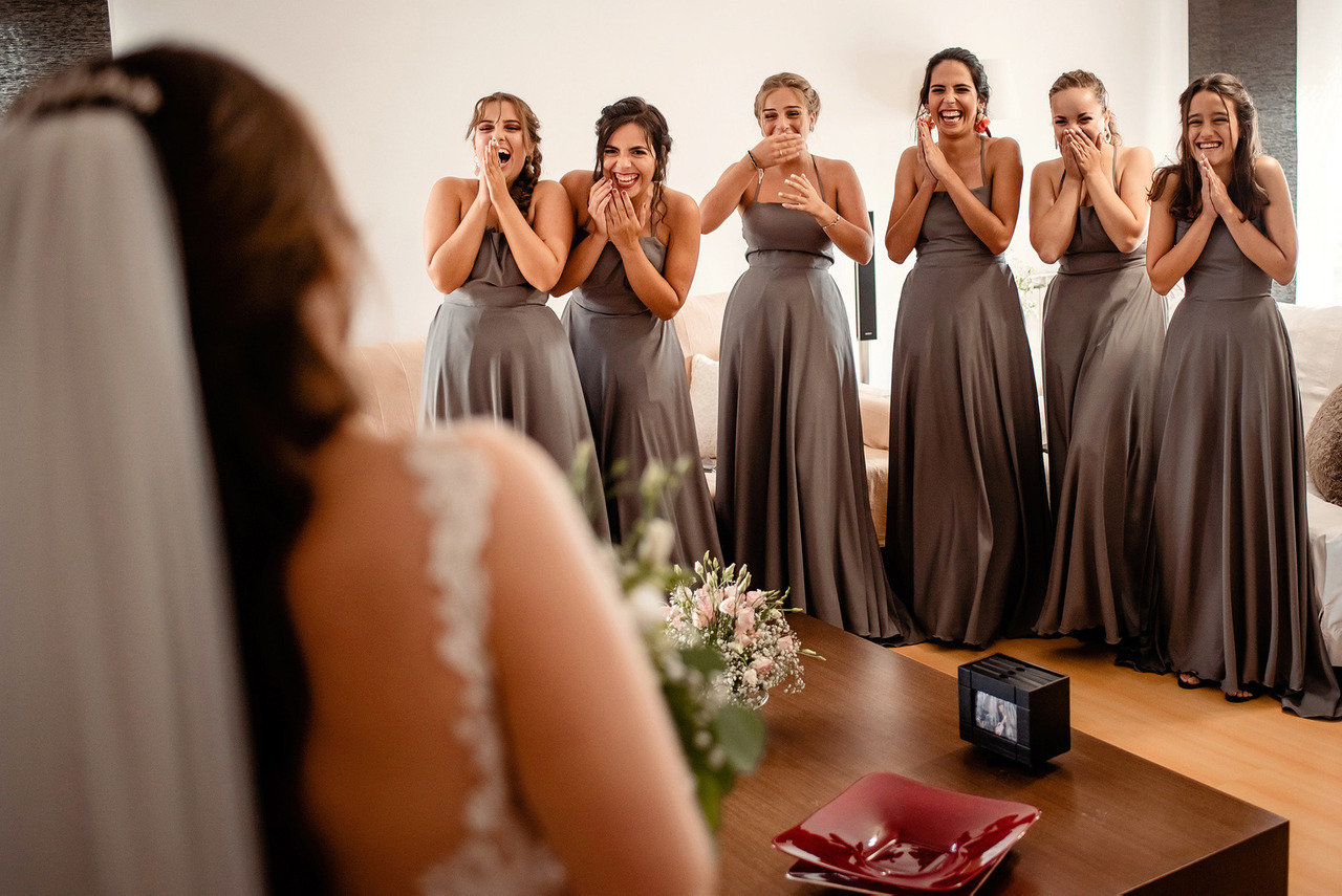 Madrinhas de vestido cinzento emocionadas ao ver a noiva pronta pela primeira vez