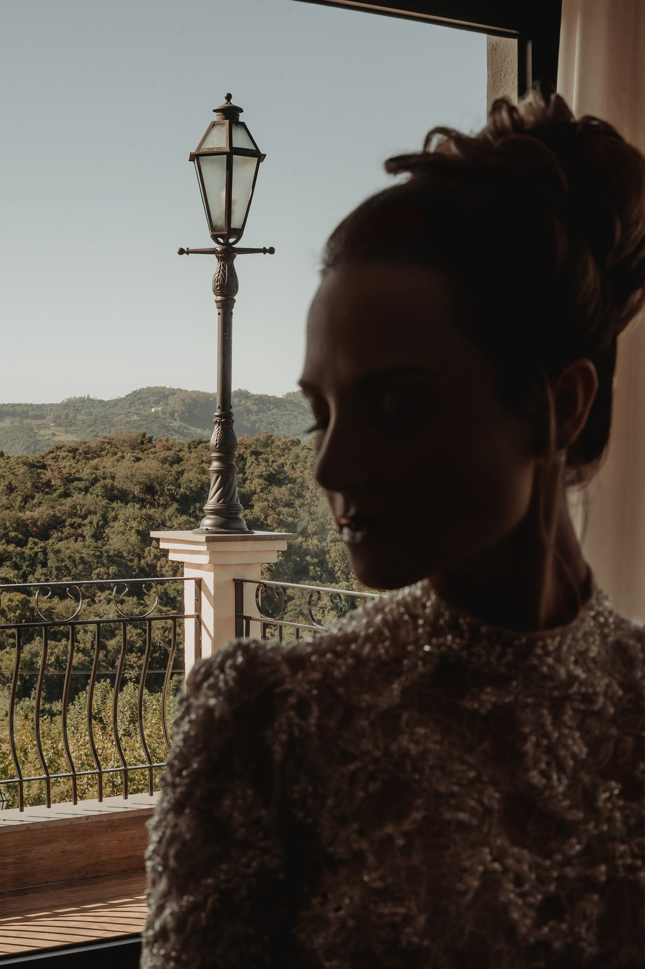 Retrato da noiva em contraluz junto à janela, com vista para os montes, antes do casamento