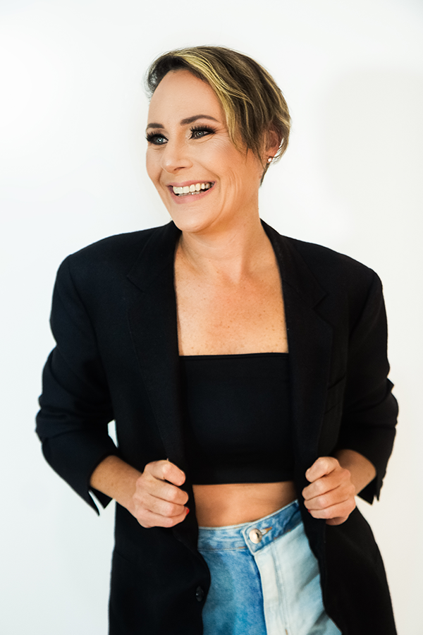 ensaio sensual-studio mais office-studio + office-ensaio sensual interno-fotografia feminina em porto alegre-foto sensual em porto alegre-mulher bonita de cabelo loiro curto usando um top preto com blazer preto por cima-autoestima-sorriso-fotografia