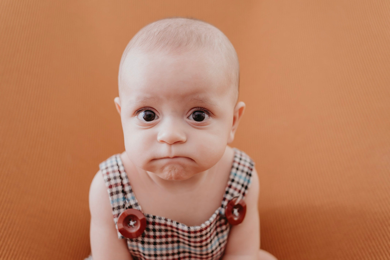 Um bebê faz cara de bravo por não ter colo suficiente