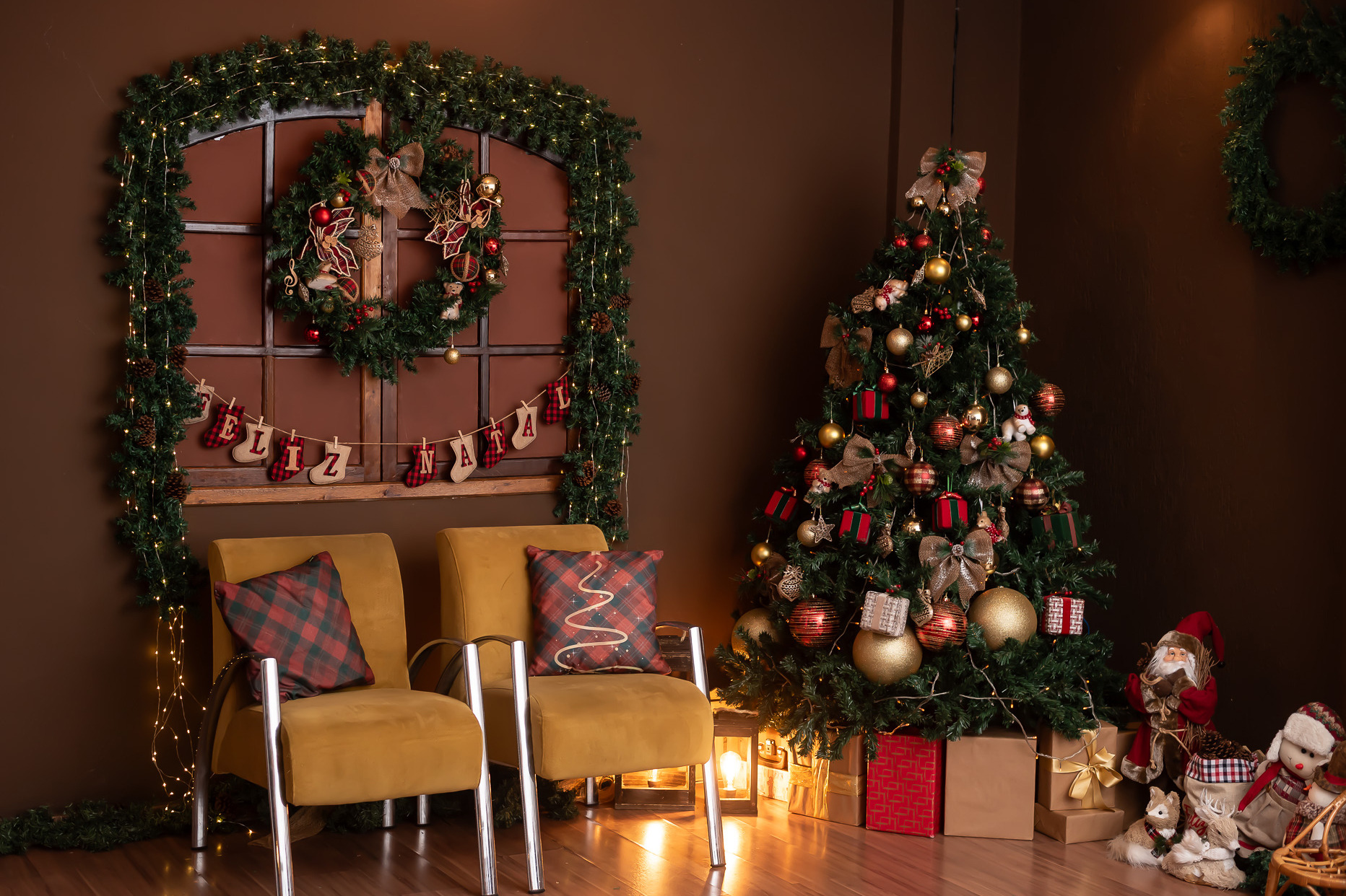 Cenário de Natal do Estúdio Abrassear com árvore, guirlanda e cadeiras